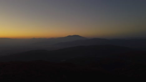 Aerial-of-mountain-silhouettes-in-beautiful-valley-at-dusk