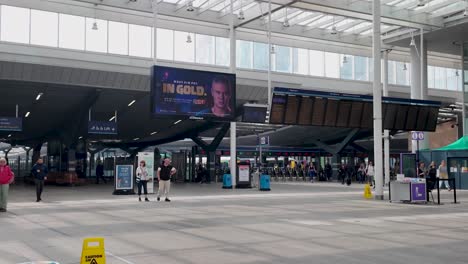 London-Bridge-Station's-interior-bustling-with-people-and-digital-advertisements