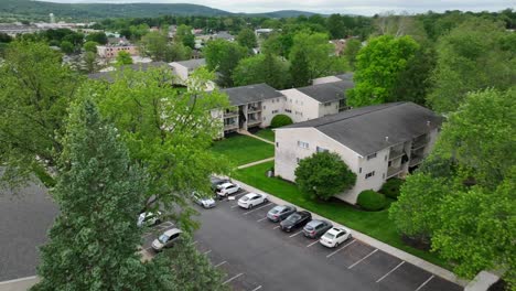 Aerial-flight-over-American-neighborhood-community-with-apartment-blocks-and-parking-cars