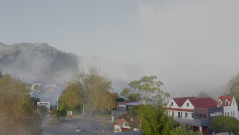 Geothermischer-Dampf-Steigt-über-Häusern-Und-Bäumen-In-Rotorua,-Neuseeland-Auf