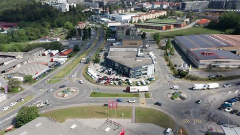 Aerial-view-of-a-large-automobile-repair-shop-on-a-busy-industrial-site-with-trucks-and-cars-driving-over-nearby-roads