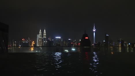 Swimmingpool-Auf-Dem-Dach-Mit-Blick-Auf-Die-Beleuchtete-Skyline-Der-Wolkenkratzer-Von-Kuala-Lumpur-Bei-Nacht