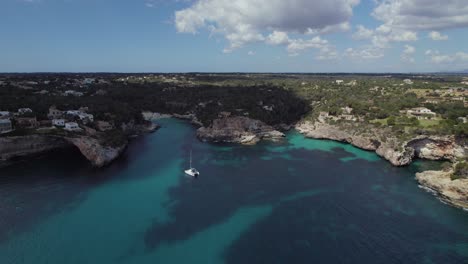 Lonely-sailing-boat-docked-in-turquoise-blue-water-in-a-bay-in-Mallorca