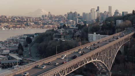 Stationäre-Drohnenaufnahme-Des-Verkehrs-Auf-Der-Aurora-Bridge-Mit-Lake-Union,-Der-Skyline-Von-Seattle-Und-Dem-Berg