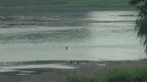 Während-Der-Trockenzeit-Des-Jialing-Flusses-Stehen-Menschen-Im-Wasser-Und-Angeln