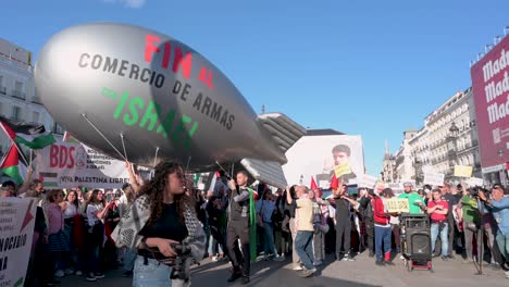 An-Der-Puerta-Del-Sol-In-Madrid,-Spanien,-Demonstrieren-Pro-palästinensische-Demonstranten,-Darunter-Einige-Mit-Einem-Ballon,-Der-Eine-Bombe-Darstellt,-Gegen-Waffenverkäufe-An-Israel