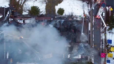 Firefighters-battling-a-school-blaze-in-montreal,-smoke-billowing,-dusk-setting-in,-emergency-response-in-action,-aerial-view