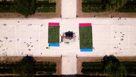 Top-down-shot-overhead-sports-courts-filled-with-school-children-in-a-park