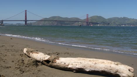 Golden-Gate-Bridge-Im-Hintergrund-Mit-Totem-Holz-An-Einem-Strand-Im-Vordergrund,-San-Francisco,-Kalifornien,-USA