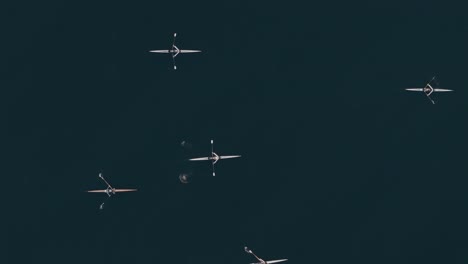 Birdseye-Tracking-Drone-Shot-of-Rowers-on-a-Dark-Lake