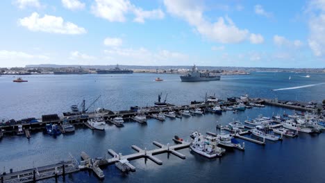 Tuna-Harbor-and-naval-ship-sailing-into-port-in-San-Diego,-aerial-view