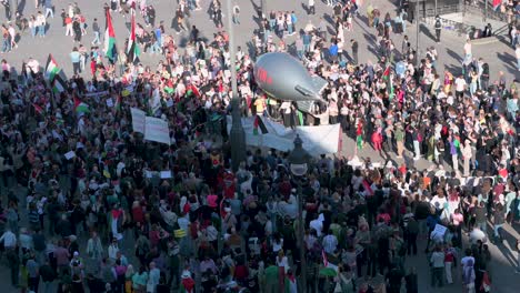 An-Der-Puerta-Del-Sol-In-Madrid,-Spanien,-äußern-Pro-palästinensische-Demonstranten,-Darunter-Einige,-Die-Einen-Ballon-Mit-Der-Abbildung-Einer-Bombe-Hochhalten,-Ihre-Opposition-Gegen-Waffenverkäufe-An-Israel.