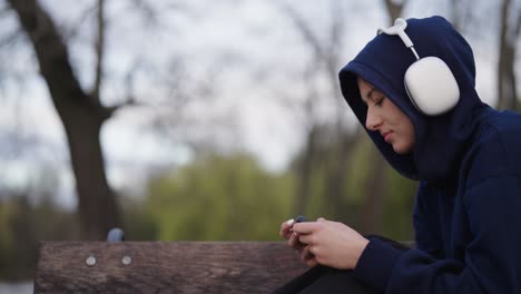 Gelangweilte-Frau-Nutzt-Kabellose-Kopfhörer-Und-Smartphone-Als-Outdoor-Aktivität