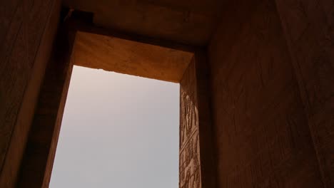 View-of-Temple-Through-Stone-Gateway,-Slow-Motion-Tilt-Up