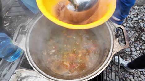 Thevideo-shows-the-preparation-of-a-delicious-soup-with-fresh-ingredients-over-a-campfire