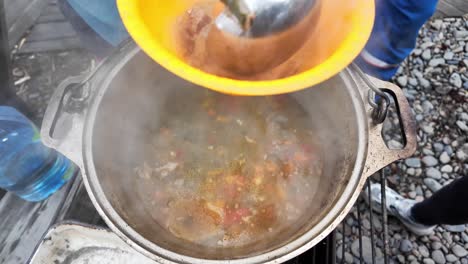 Das-Video-Zeigt-Die-Zubereitung-Einer-Leckeren-Suppe-Mit-Frischen-Zutaten-über-Einem-Lagerfeuer