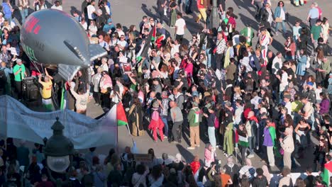 Demonstranten-An-Der-Puerta-Del-Sol-In-Madrid,-Spanien,-Fordern-Ein-Ende-Der-Waffenverkäufe-An-Israel.-Einige-Halten-Aus-Solidarität-Mit-Palästina-Einen-Ballon-Mit-Der-Abbildung-Einer-Bombe-Hoch.