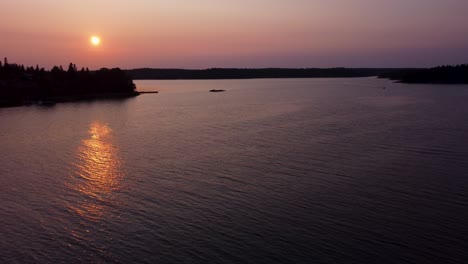 Sunset-over-Stockholm-Archipelago,-serene-waters-with-reflections,-aerial-view