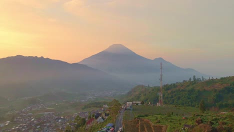 Beauty-of-Mount-Sumbing-during-sunset-with-township-bellow,-aerial-drone-view