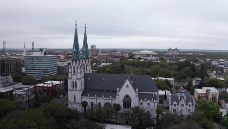 Low-panning-aerial-shot-of-the-historic-Cathedral-Basilica-of-Saint-John-the-Baptist-in-Savannah,-Georgia