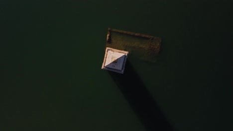 Vilanova-de-sau-and-pantano-in-spain,-capturing-a-shadowed-structure-over-water,-aerial-view