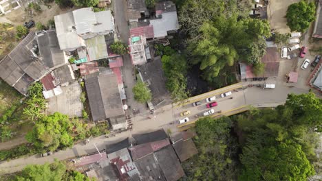 Aerial-top-down-bird's-eye-view-of-cars-and-motorbikes-driving-in-old-rural-town-of-Minca-Colombia