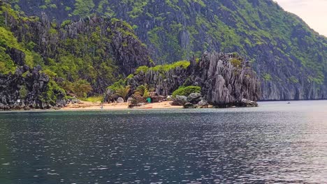 Versteckter-Tropischer-Strand-Und-Holzhütte-Unter-Kalksteinfelsen,-El-Nido,-Palawan,-Philippinen