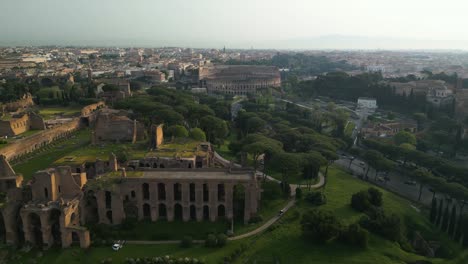 Toma-Aérea-Deslizante-Revela-La-Colina-Palatina-Y-El-Antiguo-Coliseo-Romano-Al-Fondo