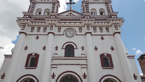 Weiße-Und-Rote-Kirche-Mit-Einem-Uhrturm-Unter-Blauem-Himmel-In-Guatapé,-Kolumbien