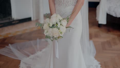 Elegant-bride-holding-white-floral-bouquet-in-lace-wedding-dress