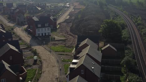 Abandoned-unfinished-housing-neighbourhood-estate-development-aerial-view-circling-across-real-estate-rooftops