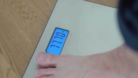 Closeup-shot-of-man-stepping-on-a-weight-scale