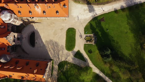 Top-down-drone-pan-of-Cesvaines-castle-front-entrance-grand-lawn-and-towers