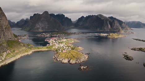 Vista-Aérea-De-Reina-Con-Hermosa-Luz-Del-Sol-Y-Las-Montañas-Al-Fondo,-Islas-Lofoten,-Noruega
