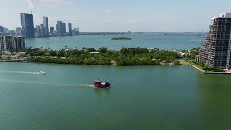 Aerial-view-around-a-old-fishing-boat-leaving-Miami,-sunny-day-in-Florida,-USA