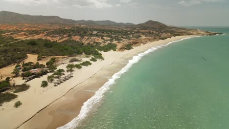 Aerial-panning-shot-of-sandy-beach-on-Margarita-Island,-Macanao-during-sunny-day