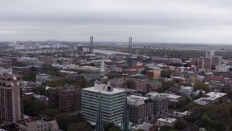 Wide-reverse-aerial-pullback-shot-of-the-gothic-spires-atop-the-Cathedral-Basilica-of-Saint-John-the-Baptist-in-Savannah,-Georgia