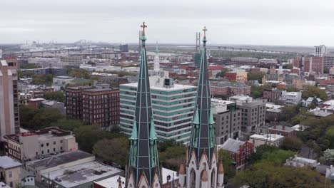 Primer-Plano-Aéreo-De-Las-Agujas-Góticas-En-Lo-Alto-De-La-Basílica-Catedral-De-San-Juan-Bautista-En-Savannah,-Georgia