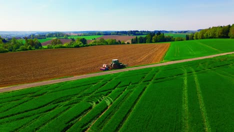 Vista-Aérea-Del-Tractor-Trabajando-En-Tierras-De-Cultivo-Verdes-Y-Marrones-En-El-Campo.