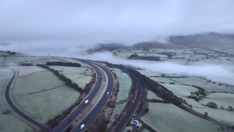 Leichter-Verkehr-Auf-Der-Autobahn-M6-Mit-Niedriger-Wolkendecke-Auf-Den-Hügeln-An-Einem-Frostigen-Wintermorgen-Mit-Nebel-Im-Tal