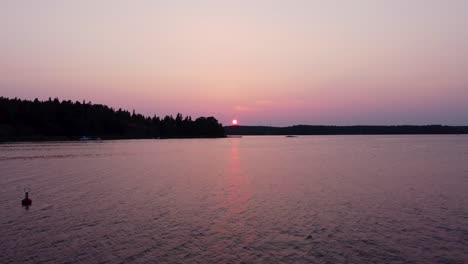 Agua-De-Mar-Tranquila-Y-Puesta-De-Sol-Roja-Sobre-El-Archipiélago-De-Estocolmo,-Vista-Estática