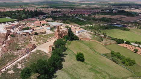 Old-belchite-town-ruins-surrounded-by-green-fields-in-zaragoza-spain,-aerial-view