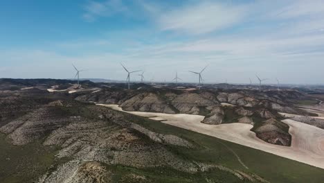 Wind-turbines-spin-on-the-hills-of-Old-Belchite-Town-Zaragoza-Spain-under-a-blue-sky