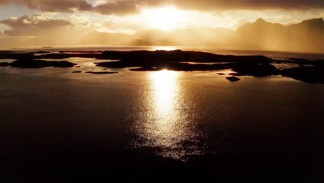 Aerial-tilt-up-reveal-of-an-incredible-sunset-over-the-fjords-of-the-Lofoten-Islands,-Norway