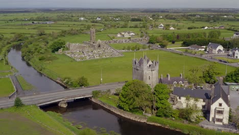 Claregalway-Friary-and-castle-by-river-Clare-in-Ireland,-panoramic-establishing-orbit