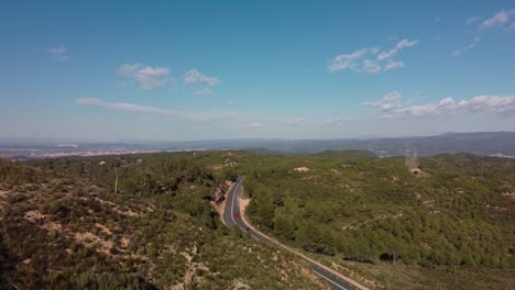 A-winding-road-through-the-lush-green-hills-of-Montserrat,-Spain-on-a-sunny-day