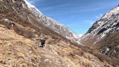 Following-hikers-and-passing-by-locals-on-the-Langtang-valley-Trek-of-Nepal,-Himalayas