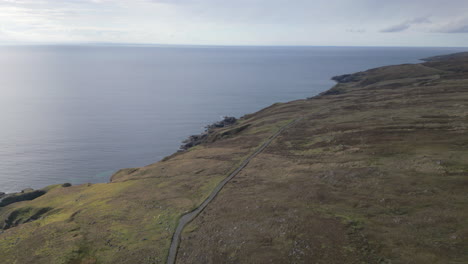 Eine-Malerische-Luftaufnahme-Von-Melvaig,-Schottland-Mit-Einer-Einsamen-Straße,-Die-Sich-Entlang-Der-Zerklüfteten-Küste-Schlängelt