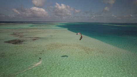 Luftaufnahme-Eines-Kitesurfers,-Der-über-Das-Klare-Wasser-Von-Los-Roques-Gleitet