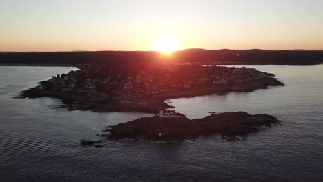 Luftbild-Drohnenvideo-Der-Meeresküste-Und-Des-Leuchtturms-Bei-Sonnenuntergang-Am-Nubble-Lighthouse-In-Der-Nähe-Von-Cape-Neddick-Und-York-Beach,-Maine,-Vereinigte-Staaten-Von-Amerika